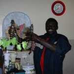 The guy who sold us fresh fish each day holding up giant shrimp like things we ate one night. They came from 'The Gambia'